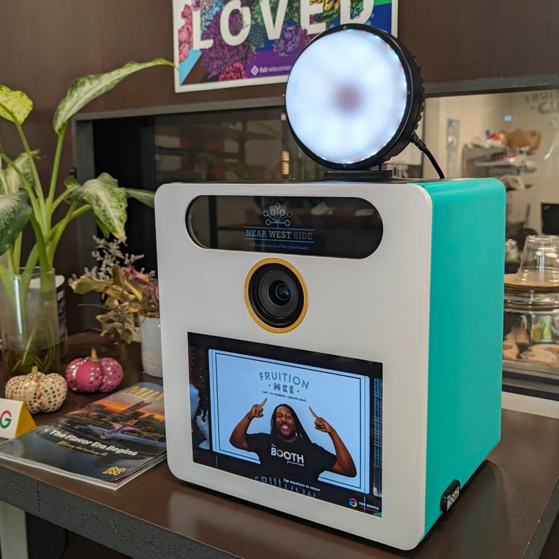 The Booth with a white face and teal sides on a shelf
