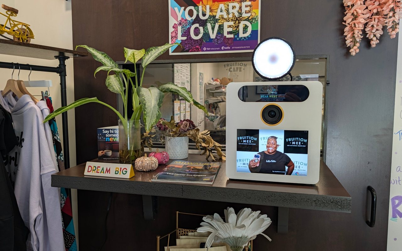 The Booth Mini on a shelf at Fruition MKE, between a plant and the coffee bar